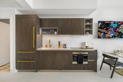 a kitchen with wooden cabinets and a table and a counter at Exclusive Studio with City Views in Downtown Miami in Miami