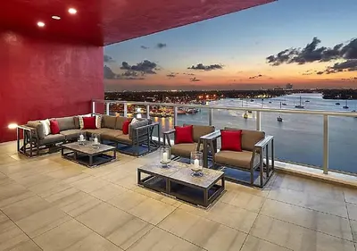 a patio with couches and tables on a balcony at A Fantastic apart with balcony and partial view of the beach 4 Px in Hollywood