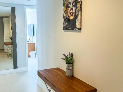 a living room with a table and a painting on the wall at Luxury 3 bedroom condo with pool in Hallandale Beach