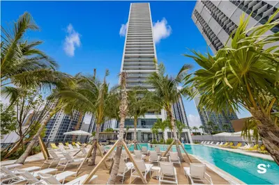 a swimming pool with chairs and a tall building at Modern Studio in Downtown Miami with Stunning City Views in Miami