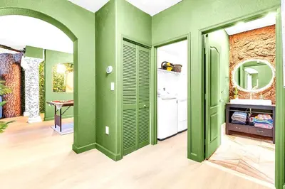 a room with green walls and a white refrigerator at Luxury Glow Villa Miami - 4K Private Cinema, Heated Pool & Spa, Game Room - 5BR Lakefront Estate for 12 Guests in Hammocks