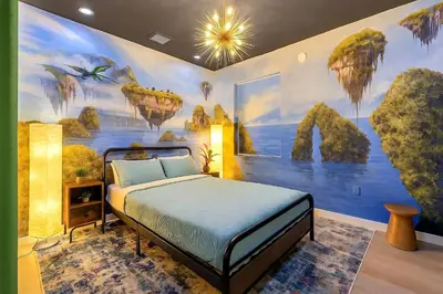 a bedroom with a bed with a painting on the wall at Luxury Glow Villa Miami - 4K Private Cinema, Heated Pool & Spa, Game Room - 5BR Lakefront Estate for 12 Guests in Hammocks