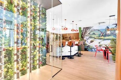 a room with a mural of plants on the wall at Luxury Glow Villa Miami - 4K Private Cinema, Heated Pool & Spa, Game Room - 5BR Lakefront Estate for 12 Guests in Hammocks