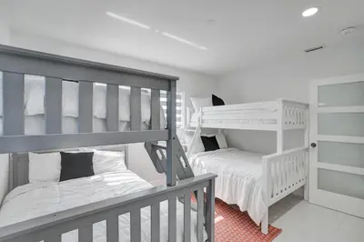 a bedroom with two bunk beds and a crib at Luxe Haven Near Aventura in Ives Estates