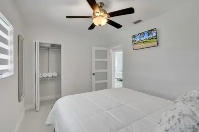 a white bedroom with a bed and a ceiling fan at Luxe Haven Near Aventura in Ives Estates