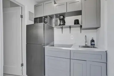 a kitchen with white cabinets and a stainless steel refrigerator at Serene Suite Near Aventura in Ives Estates