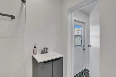 a white bathroom with a sink and a shower at Serene Suite Near Aventura in Ives Estates