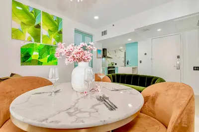 a white vase with flowers on a table in a room at 2-Min to Beach, Upscale Enclave in Miami Beach