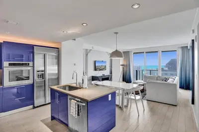 a kitchen with purple cabinets and a dining room with a view at Luxury Beachfront Two Bedroom Condo - W Residences in Fort Lauderdale
