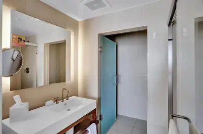 a bathroom with a sink and a mirror and a shower at Luxury Beachfront Two Bedroom Condo - W Residences in Fort Lauderdale