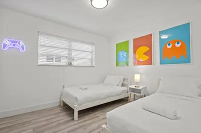 a white bedroom with two beds and a window at Pool, golf & 4 mi. from the beach & The Hard Rock in Hollywood