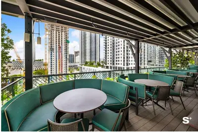 a balcony with tables and chairs and a view of a city at Studio in DTW Miami - City Views & Gym in Miami