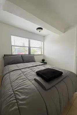 a bedroom with a large bed in a white room at Pacifica Fort Lauderdale Airport in Dania Beach