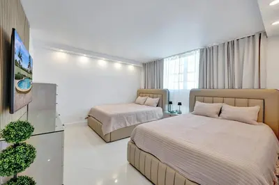 a hotel room with two beds and a television at Luxury Oceanfront 3 Bedroom condo on the beach 16 Floor in Hollywood