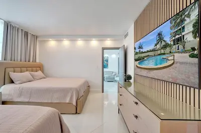 a bedroom with two beds and a tv on the wall at Luxury Oceanfront 3 Bedroom condo on the beach 16 Floor in Hollywood