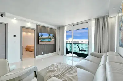 a living room with a white couch and a tv at Luxury Oceanfront 3 Bedroom condo on the beach 16 Floor in Hollywood