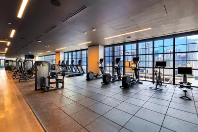 a gym with tread machines and people exercising in it at From 43th Floor a Luxury Condo Awaits For You! in Miami
