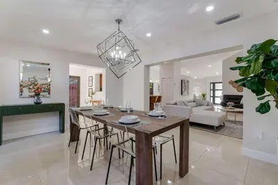 a dining room and living room with a table and chairs at Casa Brisa - Stylish BBQ Near heart of Kendall in Miami