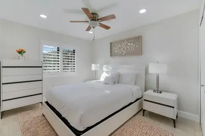 a white bedroom with a bed and a ceiling fan at Casa Brisa - Stylish BBQ Near heart of Kendall in Miami