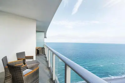 a view of the ocean from the balcony of a resort at City Lights and Skyline Nights - High-Floor Stay in our Luxury Apartment in Hollywood
