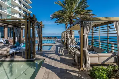 a resort pool with lounge chairs and palm trees at City Lights and Skyline Nights - High-Floor Stay in our Luxury Apartment in Hollywood