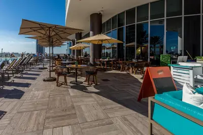 an outdoor patio with tables and chairs and umbrellas at City Lights and Skyline Nights - High-Floor Stay in our Luxury Apartment in Hollywood