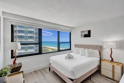 a bedroom with a bed and a large window at Classic Resort Amenities Condo Steps from the Beach with Gym and Pool 1208 in Miami Beach