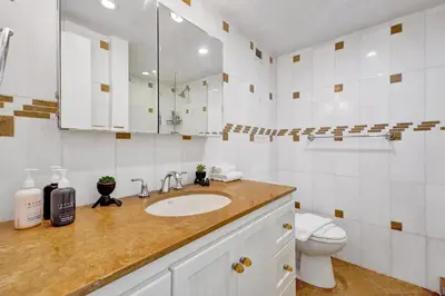a white bathroom with a sink and a toilet at Classic Resort Amenities Condo Steps from the Beach with Gym and Pool 1208 in Miami Beach