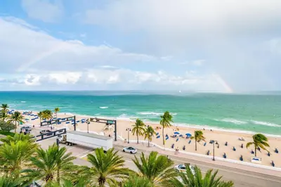 a view of a beach with palm trees and the ocean at 16th Floor Luxury 2 Bedroom - Ocean Views & Luxury in Fort Lauderdale