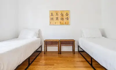 two beds with white sheets and a table in a room at Tranquil Heirloom Hideaway Pool in South Miami in Miami
