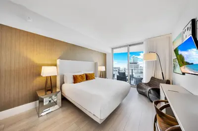 a hotel room with a bed and a desk and a window at High-End Apartment in a Luxury Resort with Gorgeous Amenities in Hollywood