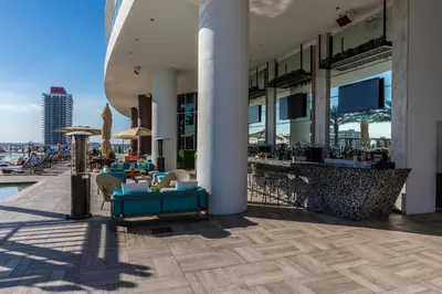 a hotel patio with tables and chairs and a pool at High-End Apartment in a Luxury Resort with Gorgeous Amenities in Hollywood