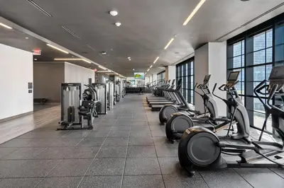 a gym with a row of treadmills and machines at Luxury 2-Bdrm Condo in the Heart of Downtown Miami in Miami