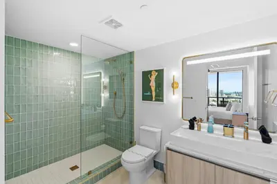 a bathroom with a toilet and a shower with green tiles at Luxury 2-Bdrm Condo in the Heart of Downtown Miami in Miami