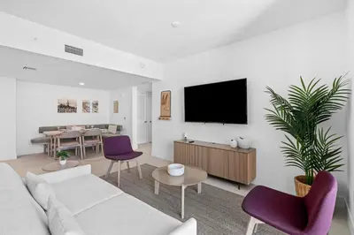 a living room with a white couch and purple chairs at Luxury 2-Bdrm Condo in the Heart of Downtown Miami in Miami