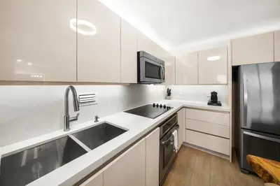 a white kitchen with a sink and a refrigerator at 1 Bedroom Private Residence at Roney Palace -1129 in Miami Beach