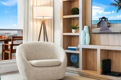 a living room with a chair in front of a window at 2 Bedroom Private Residence at Roney Palace -11289 in Miami Beach