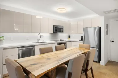 a kitchen with a wooden table and a refrigerator at 2 Bedroom Private Residence at Roney Palace -11289 in Miami Beach