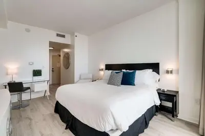 a bedroom with a large white bed with blue pillows at Cocktails & Coffee with bay & city view balconies in Miami