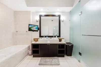 a bathroom with two sinks and a tub and a mirror at Exclusive Doral Villa with Luxury Amenities in Miami