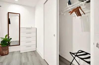 a white hallway with a mirror and a dresser at Koze 2 Bedroom Duplex Home with King & Queen Beds, Near Everything Trendy in Miami