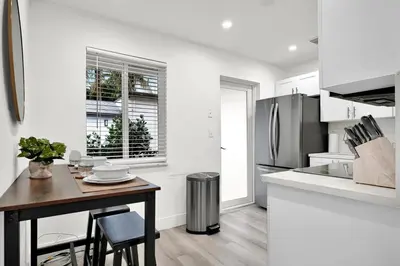a kitchen with a table and a refrigerator at Koze 2 Bedroom Duplex Home with King & Queen Beds, Near Everything Trendy in Miami