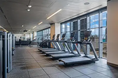 a gym with rows of treadmills in a building at 2 bedroom Stylish Condo Downtown Pool Gym spa in Miami
