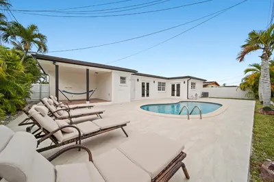 a patio with lounge chairs and a swimming pool at Miami Oasis- Pool & Game Fun in Miami