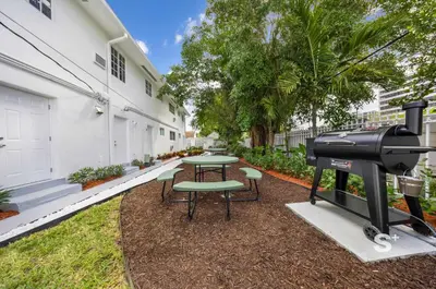 a grill and a picnic table in a yard at Modern Studio in Miami Gym, BBQ, Free Parking in Miami