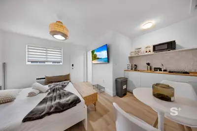 a white bedroom with a bed and a table at Modern Studio in Miami Gym, BBQ, Free Parking in Miami
