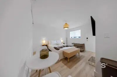 a white bedroom with a bed and a table at Modern Studio in Miami Gym, BBQ, Free Parking in Miami