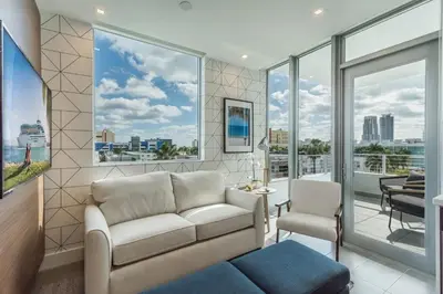 a living room with a couch and chairs and windows at Apto 2Q Estiloso a 5min da Praia de South Beach in Miami Beach