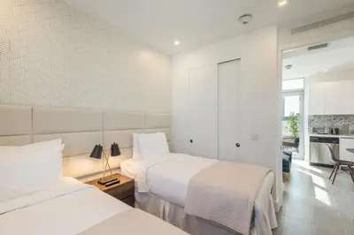 a bedroom with two beds and a kitchen at Apto 2Q Estiloso a 5min da Praia de South Beach in Miami Beach