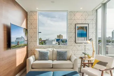 a living room with a couch and a large window at Apto 2Q Estiloso a 5min da Praia de South Beach in Miami Beach
